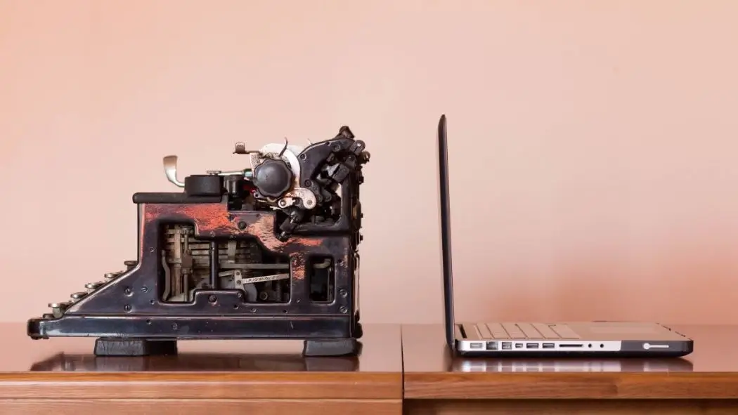 An old copywritter next to a laptop